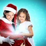 Kvinde i julemandskostume ser på en pakke til en lille pige