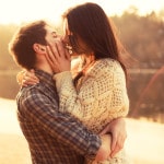 Par kysser foran stille sø - romantik